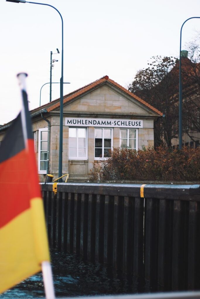 View of Muhlendamm-Schleuse in Berlin, Germany, featuring the national flag and urban architecture.