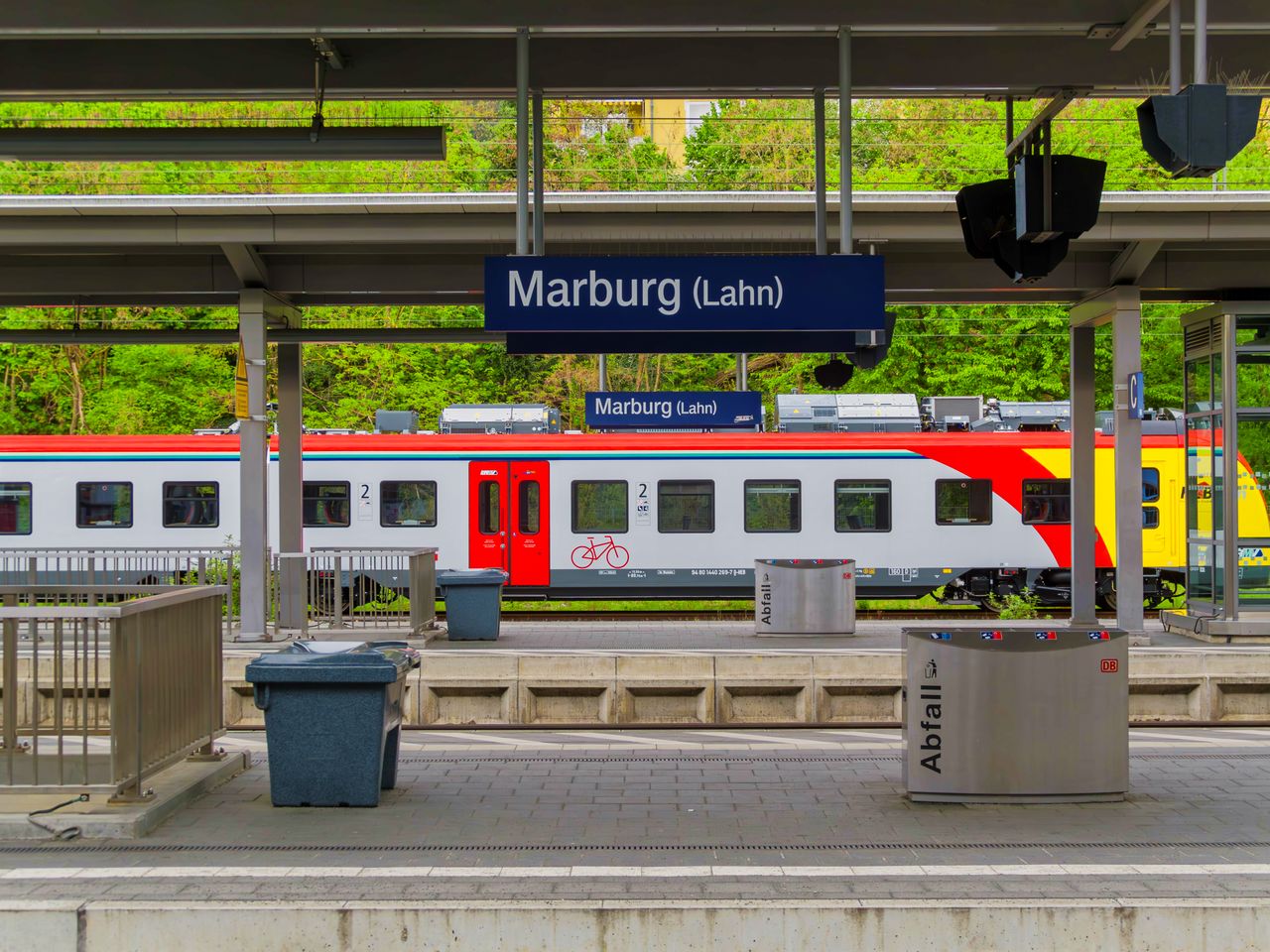 Colorful train at Marburg (Lahn) station platform, showcasing modern travel in Germany.
